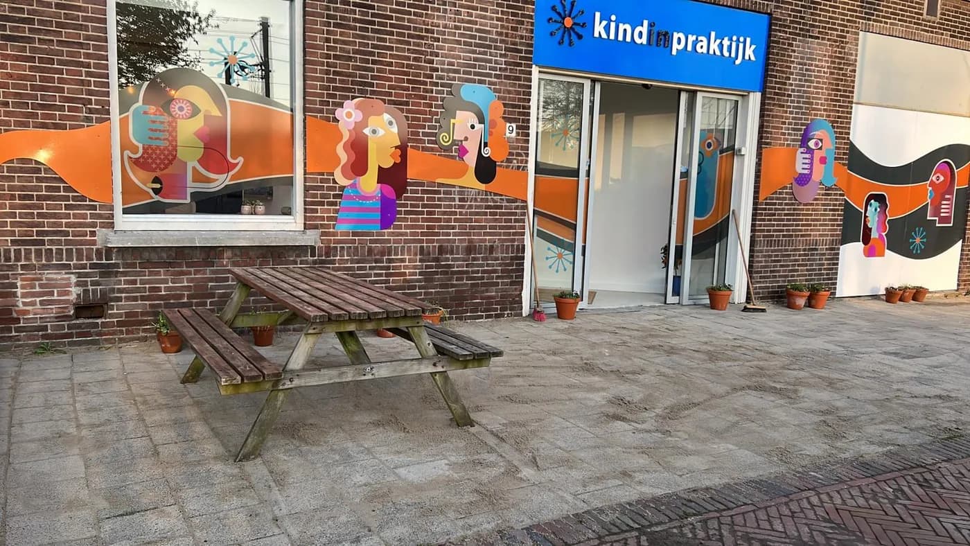De voorgevel van Kind in Praktijk in Delft, met picknicktafel voor de deur